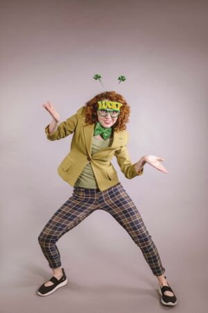 Verrückter Mittwoch Das Bild zeigt eine Person mit Verkleidung (Grüne Brille mit Lucky Schriftzug) sowie einem Haarreif aus Kleeblättern in einer Pose aus angewinkelten Armen).
